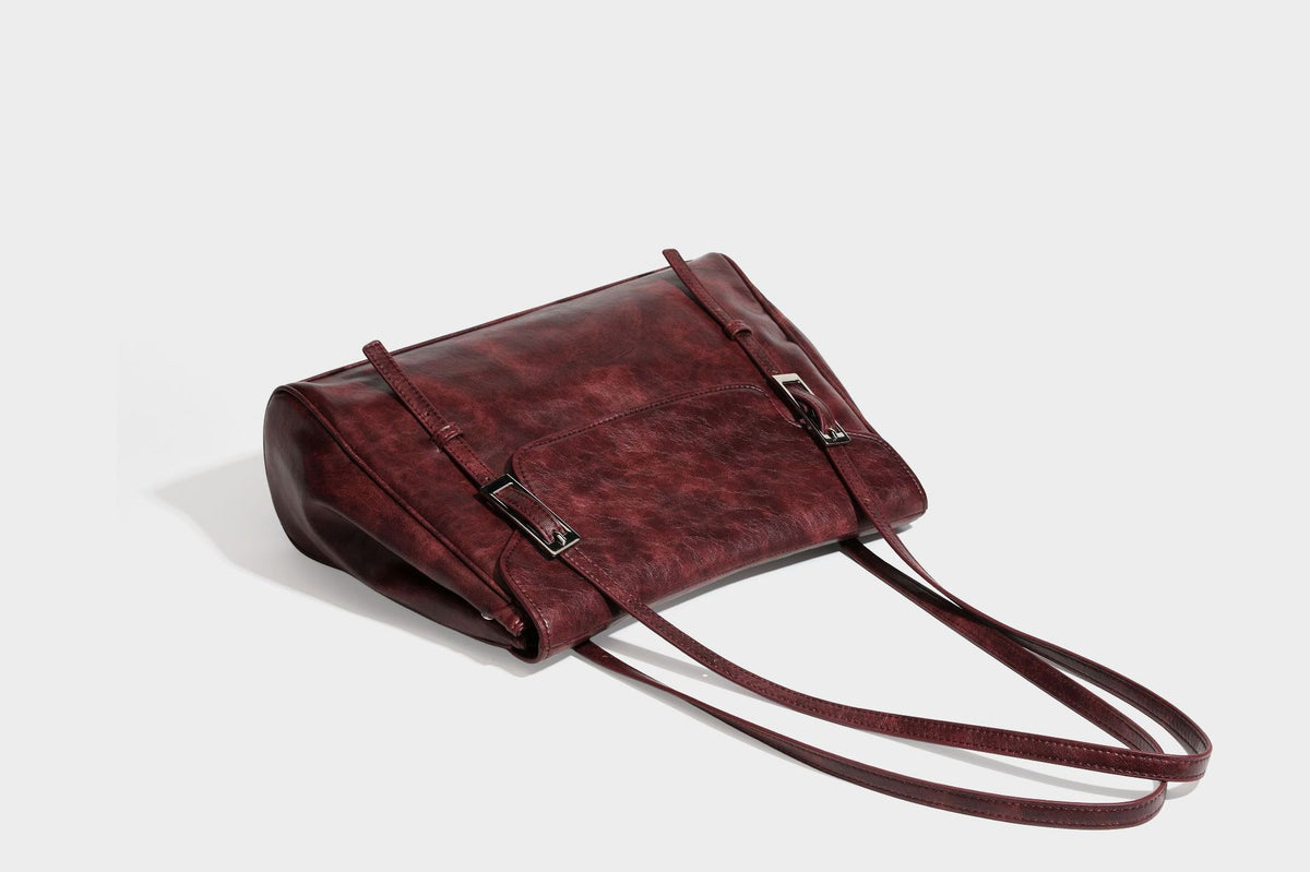 Structured flap-top shoulder tote bag in distressed leather-look finish with silver-tone buckle hardware and double shoulder