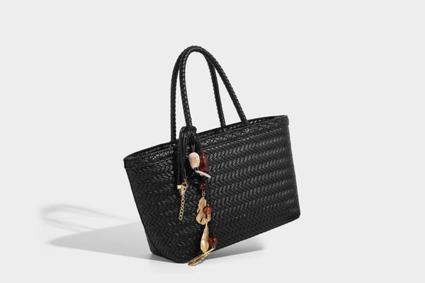 Structured chevron woven leather-look tote bag with braided top handles, gold feather charm, and adjustable shoulder strap