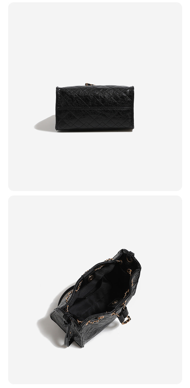 Glossy diamond-quilted drawstring bucket bag with gold-tone chain strap and eyelet hardware, detail view 16