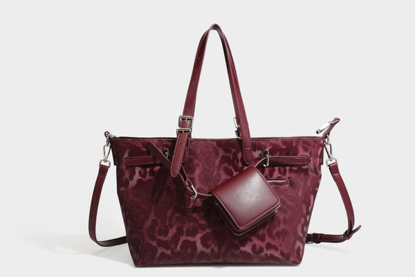 Glossy leopard-print tote bag with leather-look dark trim, dual top handles, detachable shoulder strap, and attached front