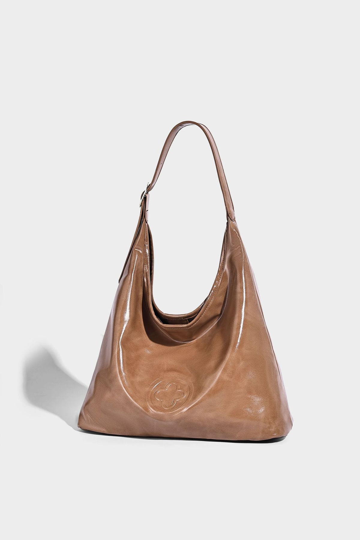 Glossy slouchy hobo shoulder bag with adjustable strap and embossed floral emblem, detail view 14