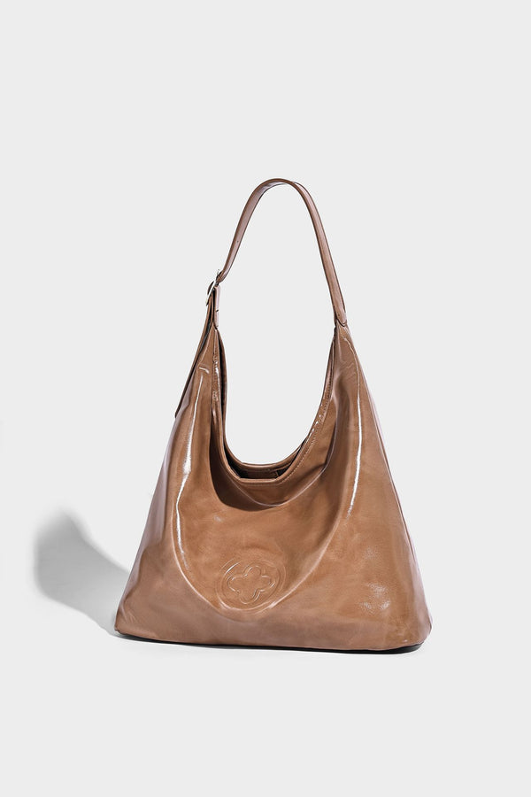 Glossy slouchy hobo shoulder bag with adjustable strap and embossed floral emblem, detail view 14