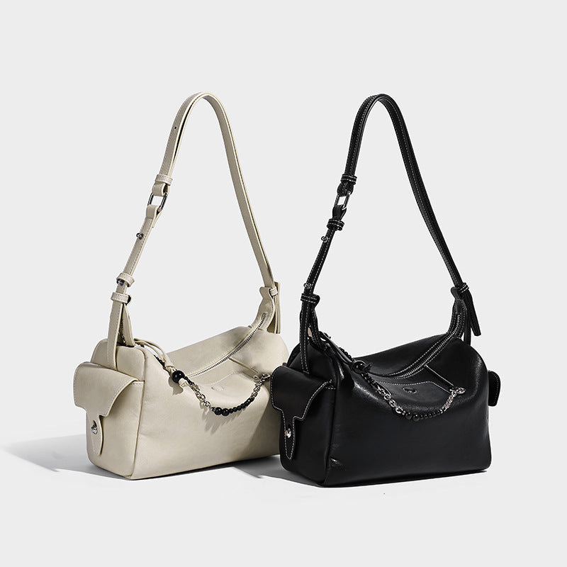 Small slouchy moto-style crossbody bag in smooth matte leather-look finish with white contrast stitching, silver-tone, detail