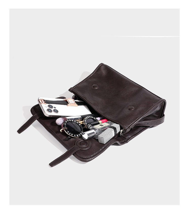 Strukturierte Satchel-Tasche mit Überschlag aus dunkelbrauner, glänzender Lederoptik, kurzem Tragegriff und langem, verstellbarem Schulterriemen