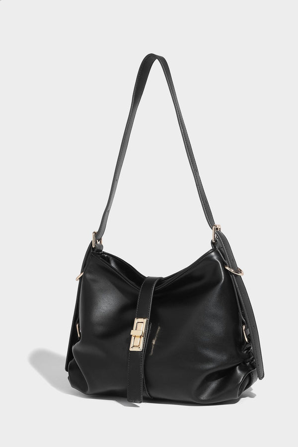 Soft slouchy hobo shoulder bag with smooth leather-look finish, gold-tone buckle and tab hardware, and long adjustable strap