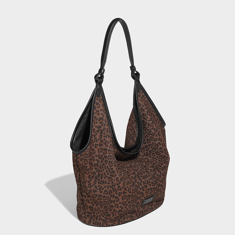 Slouchy brown leopard jacquard hobo tote bag with black leather-look trim and single shoulder strap, shown with black, detail