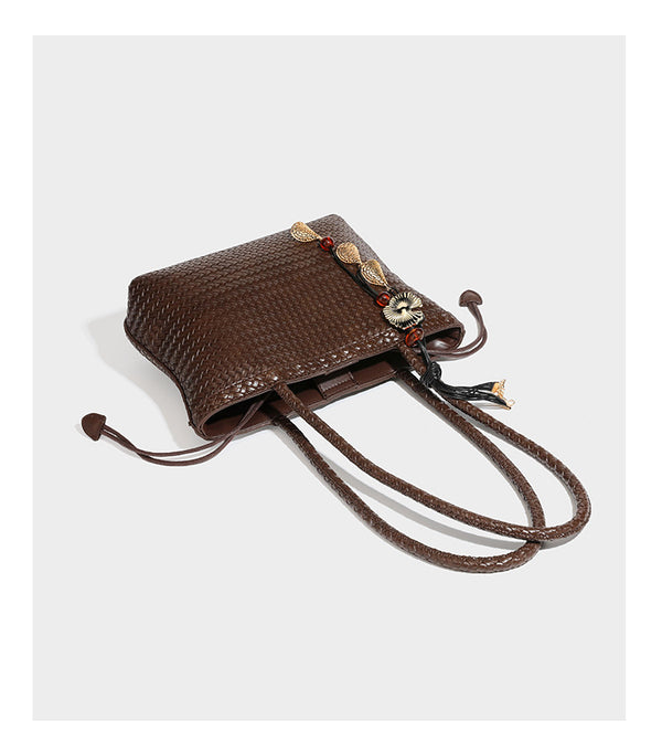 Structured woven leather-look tote bag in dark brown with long shoulder straps, side drawstring ties, and gold filigree