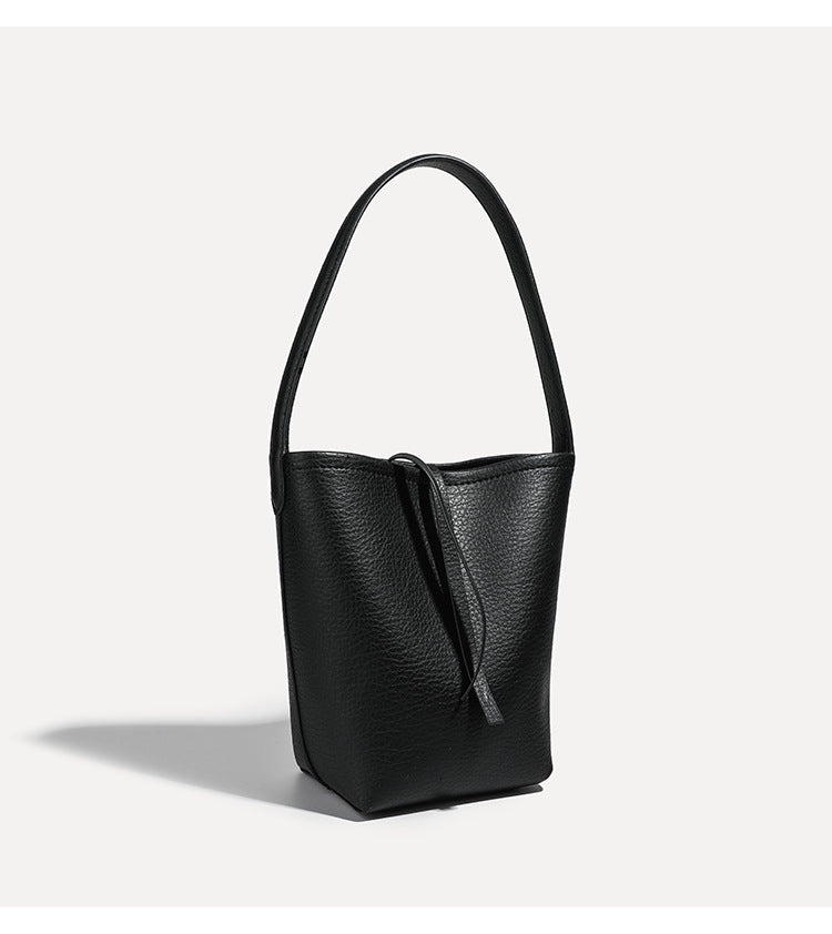 Mini tapered bucket bag in pebbled leather-look finish with front tie straps and single shoulder strap, detail view 17