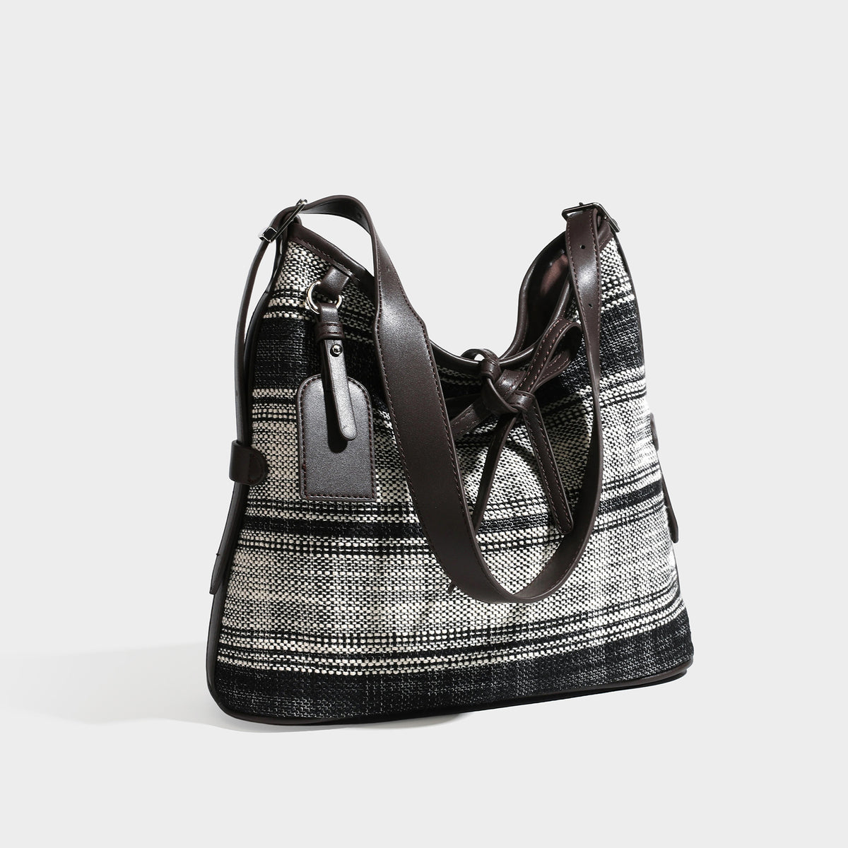 Schwarz-weiß karierte Hobo-Schultertasche aus gewebtem Material mit dunkelbrauner Einfassung in Lederoptik, Kordelzugverschluss und langem, verstellbarem