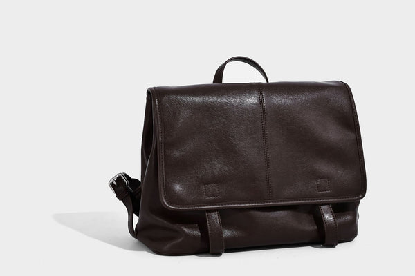 Structured tan leather-look flap backpack handbag with top handle, silver buckle hardware, and fold-over front closure