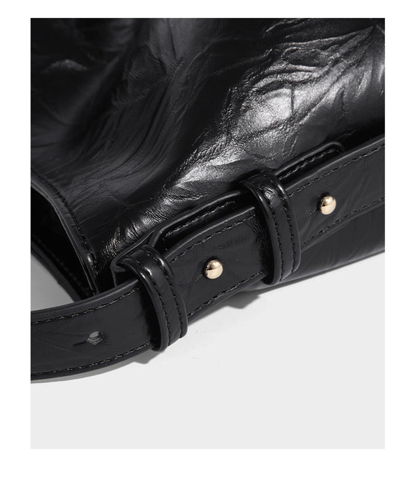 Large slouchy hobo shoulder bag in glossy crinkle leather-look finish with gold-tone emblem hardware and adjustable strap