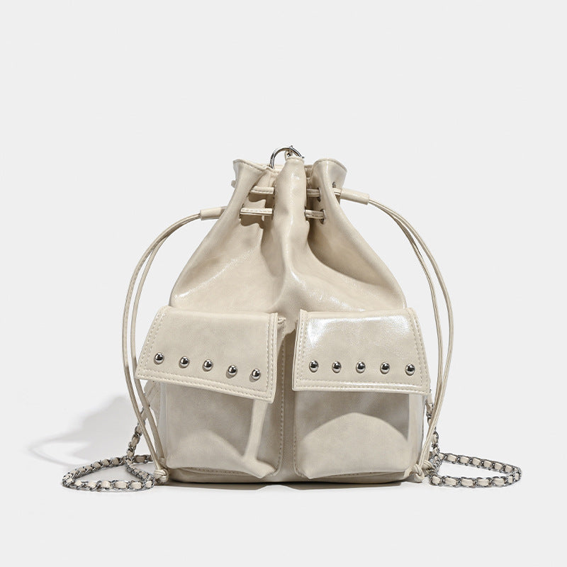 Glossy leather-look drawstring bucket bag with silver dome studs and chain shoulder strap, detail view 7