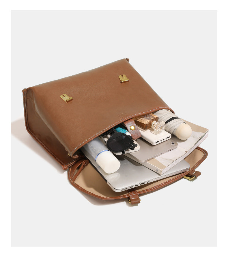Structured flap-over backpack satchel in smooth leather-look finish with gold-tone buckle hardware and top handle, detail