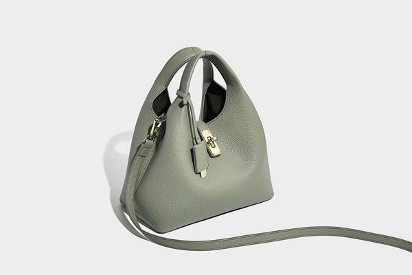 Structured pebbled-texture bucket bag with arched top handles, gold-tone turn-lock closure, and detachable shoulder strap
