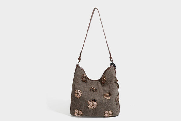 Lässig fallende Hobo-Schultertasche aus anthrazitfarbenem Webstoff mit floraler Stickerei aus silberfarbenen Pailletten, schwarzem Besatz in Lederoptik und langem