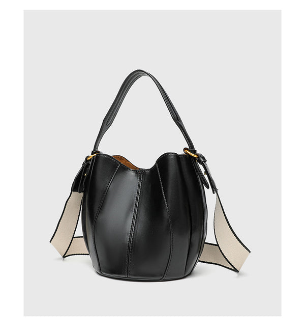 Smooth leather-look paneled bucket bag in brown with wide woven shoulder strap, gold-tone ring hardware, and detachable zip