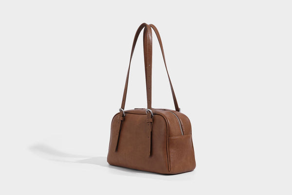 Structured dome-shaped shoulder bag with leather-look finish, top zipper closure, dual adjustable slim straps, and, detail