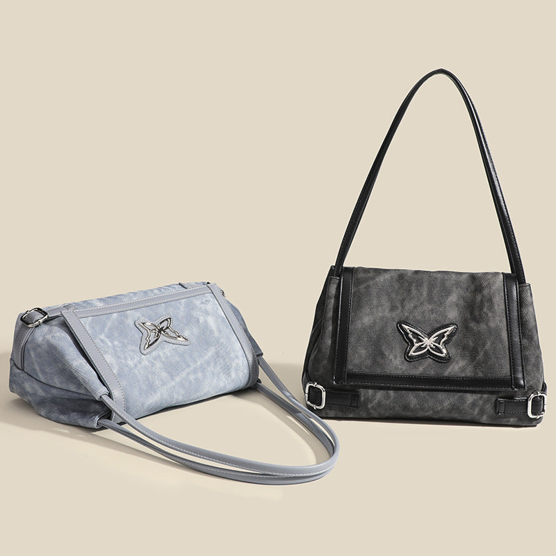 Washed leather-look shoulder tote bag with silver butterfly emblem and buckle hardware, detail view 2