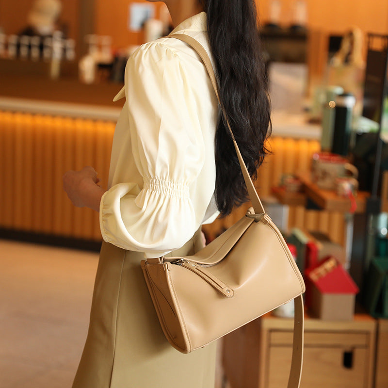 Structured smooth leather-look shoulder bag with top zip closure, tassel pull, and adjustable crossbody strap in khaki