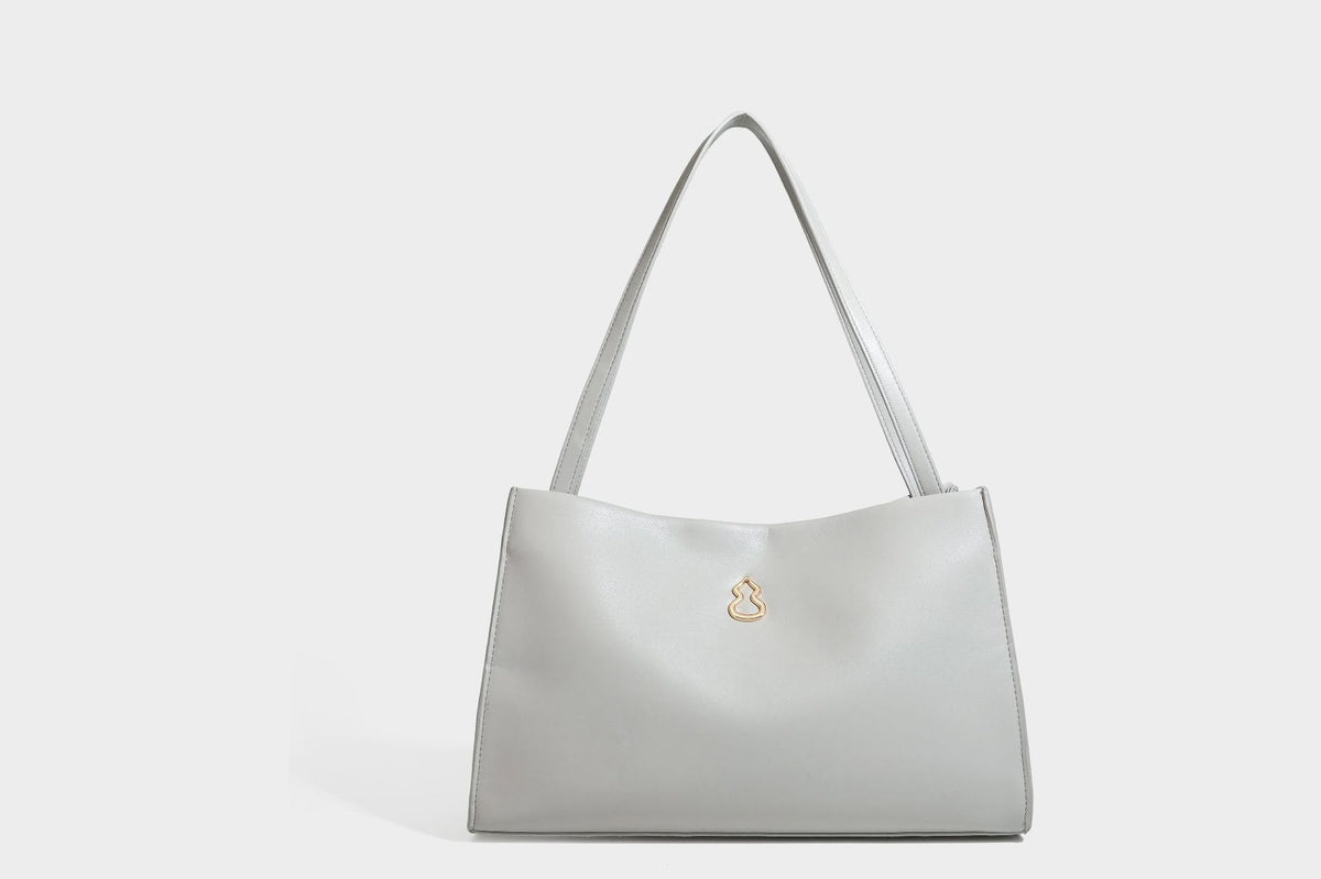 Structured rectangular shoulder tote bag with smooth leather-look finish, long double straps, and gold-tone gourd emblem on