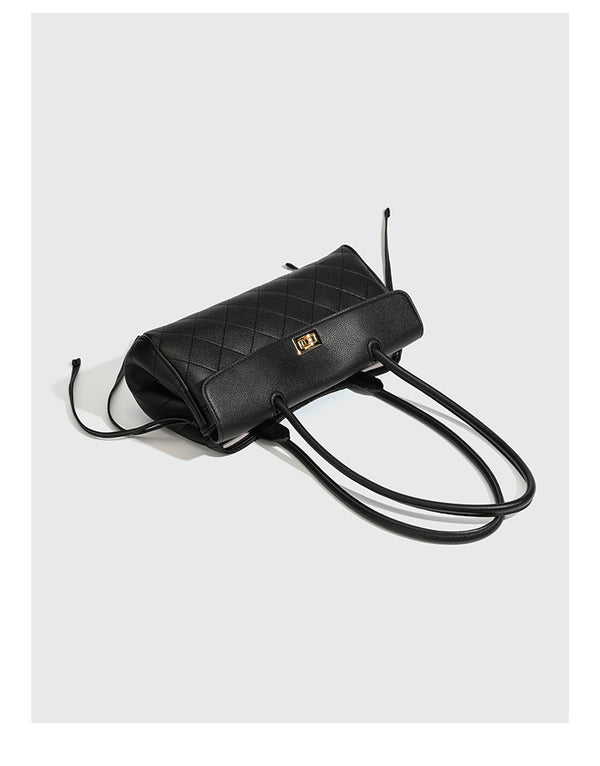 Structured black diamond-quilted shoulder bag with gold-tone turn-lock flap closure and dual round shoulder straps, detail