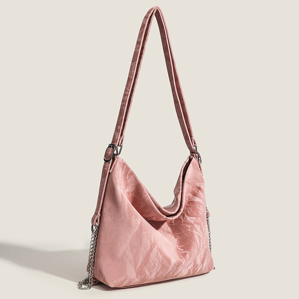 Blush pink slouchy hobo bag with crinkled sheen finish, silver-tone chain hardware, and adjustable shoulder strap, detail