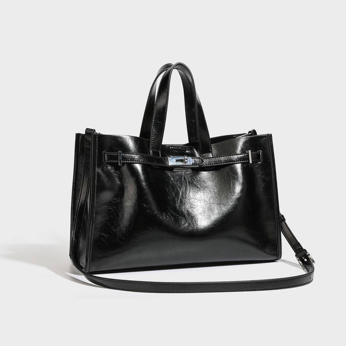 Structured glossy leather-look tote bag with silver turnlock closure, dual top handles, and detachable shoulder strap, front
