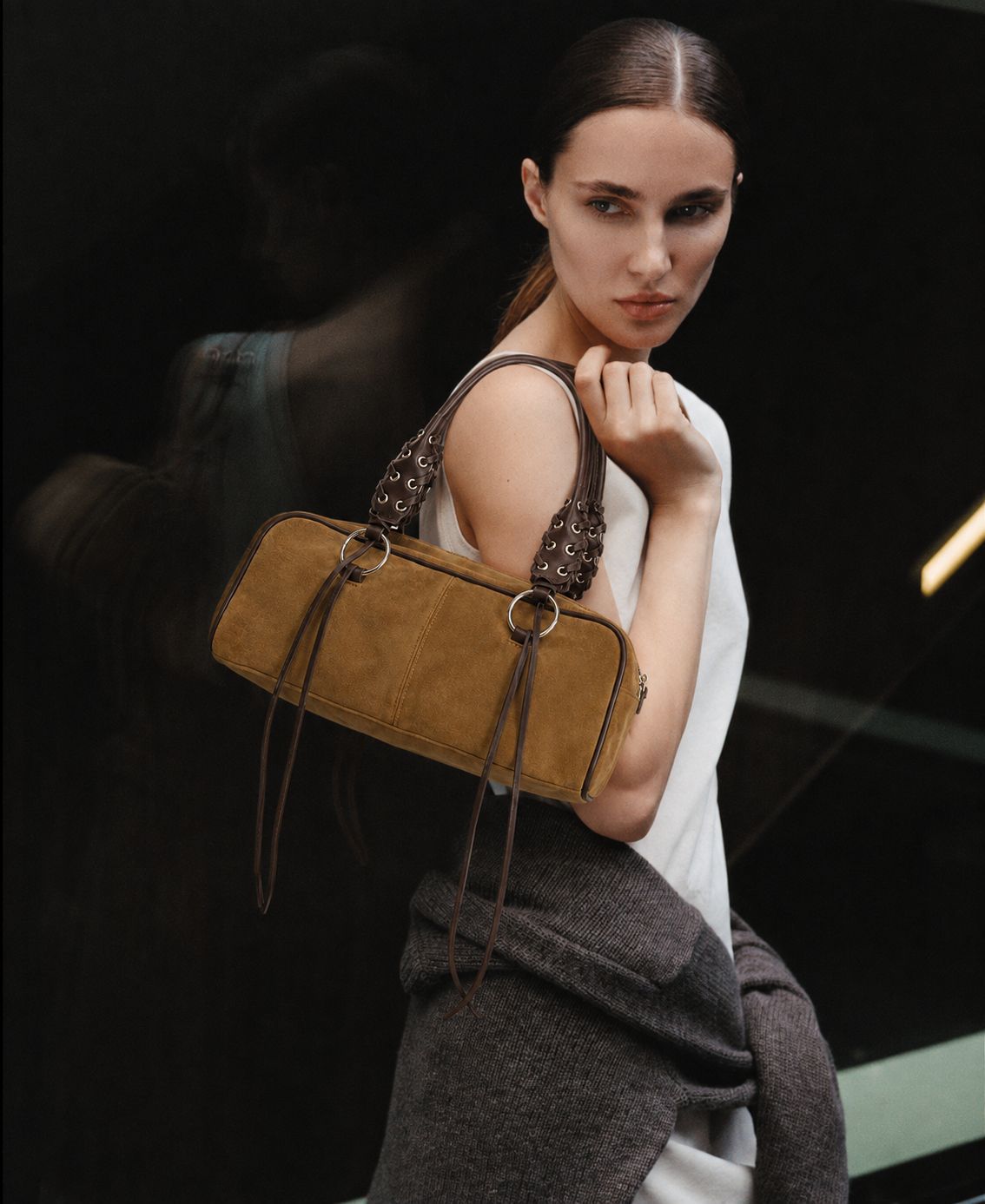 Rectangular suede-look barrel bag with laced eyelet handles, silver O-ring hardware, and hanging leather-look fringe tie