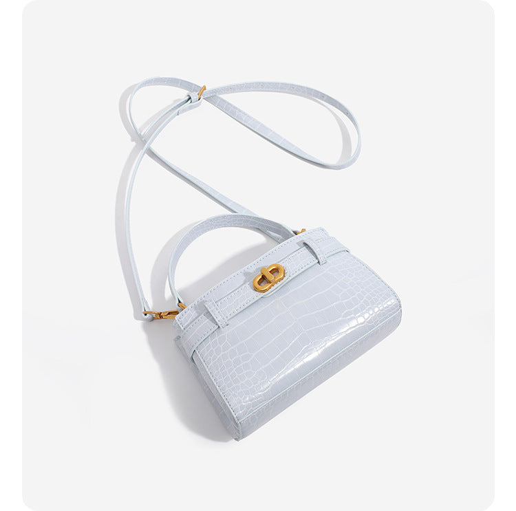 Small structured crocodile-embossed top-handle bag with gold-tone turn-lock closure and detachable shoulder strap, detail