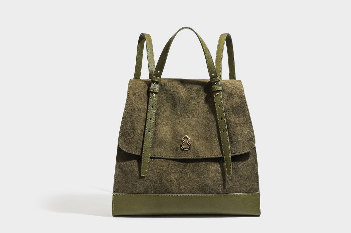Structured suede-look convertible backpack handbag with flap closure and gold-tone emblem hardware in chocolate brown, detail