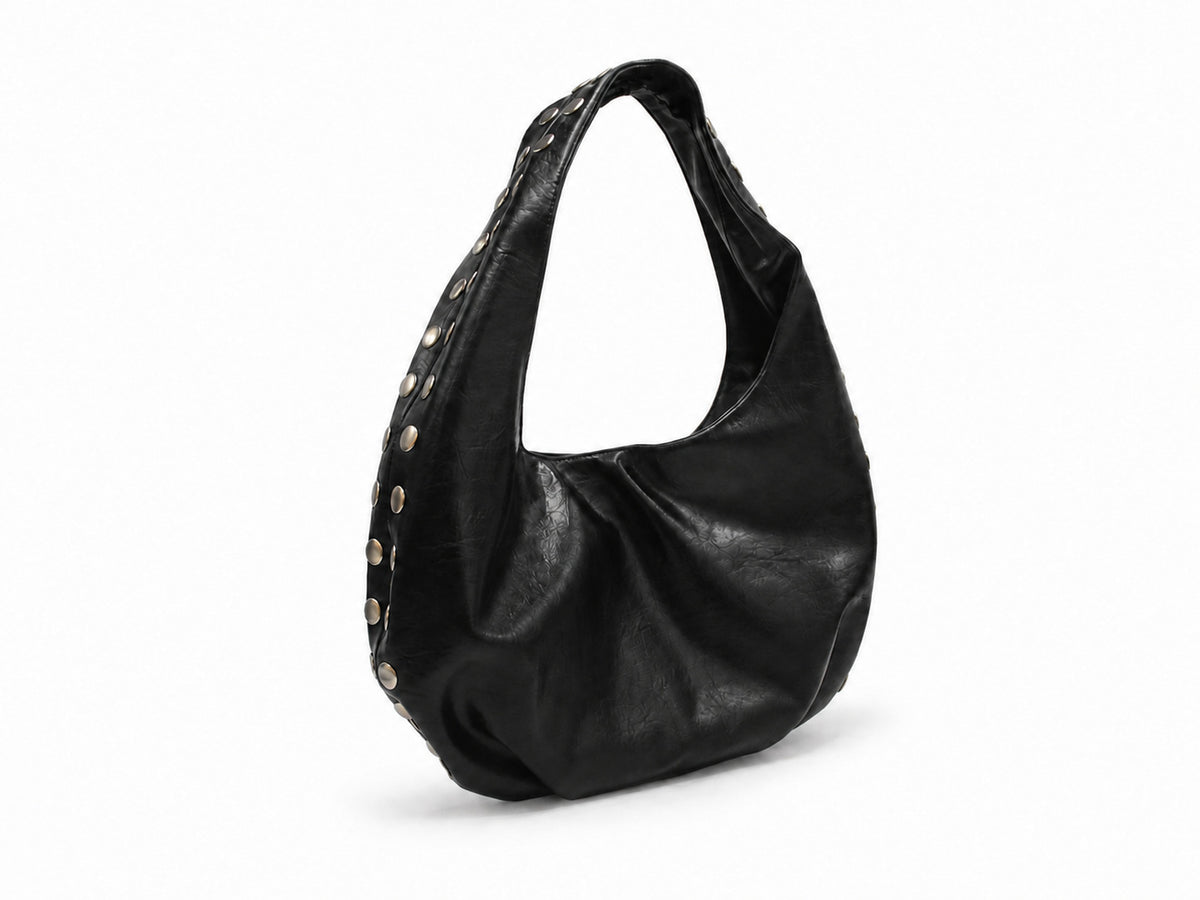 Schwarze Hobo-Bag in Lederoptik mit silberfarbenen Kuppelnieten entlang der Seitenaht und einem breiten einzelnen Tragegriff oben, Detail