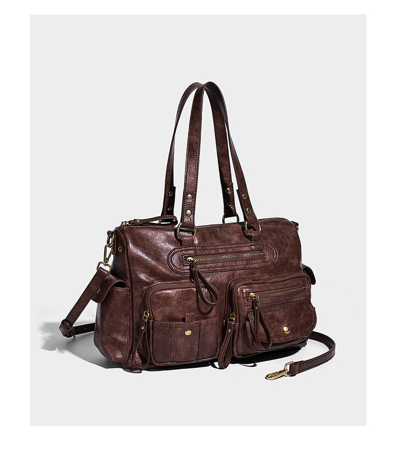 Distressed leather-look vintage satchel shoulder bag with multiple front zip pockets, dual top handles, and brass-tone