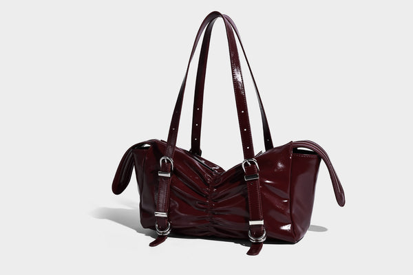 Glänzende, rechteckige Schultertasche mit Raffdetails, zwei verstellbaren Riemen, Reißverschluss oben und Schnallenbeschlägen in Silberoptik