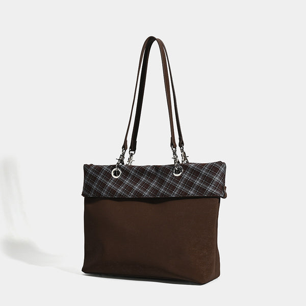 Brown structured tote bag with woven plaid fold-over top panel, silver-tone ring hardware, and long flat shoulder straps