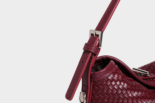 Small woven-look leather-look flap shoulder hobo bag in burgundy with silver-tone hardware and decorative tassel charm