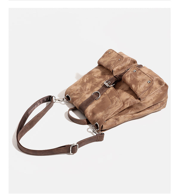 Compact distressed leather-look tan-brown backpack handbag with flap-and-buckle closure, two front patch pockets, top handle