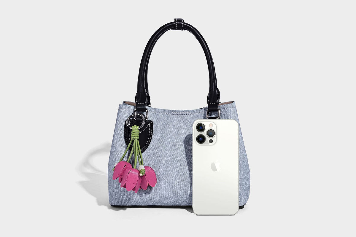 Structured light-blue denim-look tote bag with black leather-look handles, white contrast stitching, silver-tone hardware