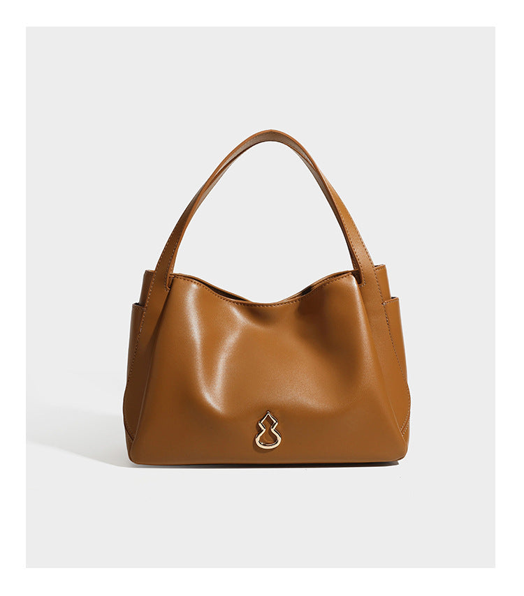 Structured glossy leather-look tote shoulder bag with dual top handles, detachable crossbody strap, side pockets, and, detail