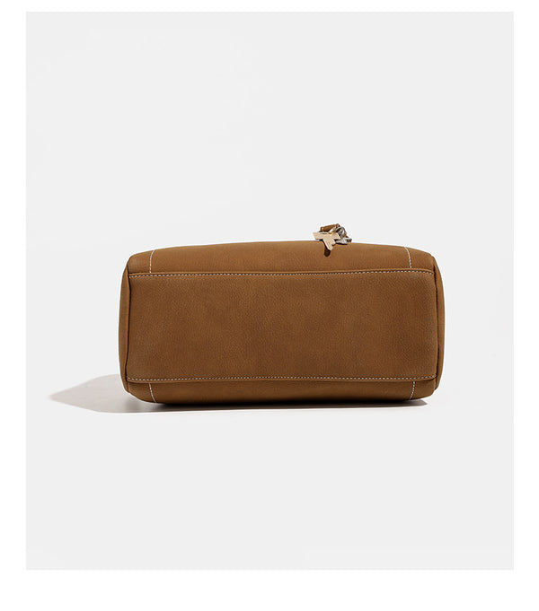 Kompakte, strukturierte Henkeltasche mit matter genarbter Oberfläche, geknoteten Doppelhenkeln, goldenem Schlüsselanhänger und abnehmbarem, Detail