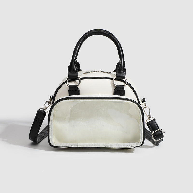 Structured mini bowling barrel bag with clear front pocket, dual top handles, and detachable crossbody strap in glossy