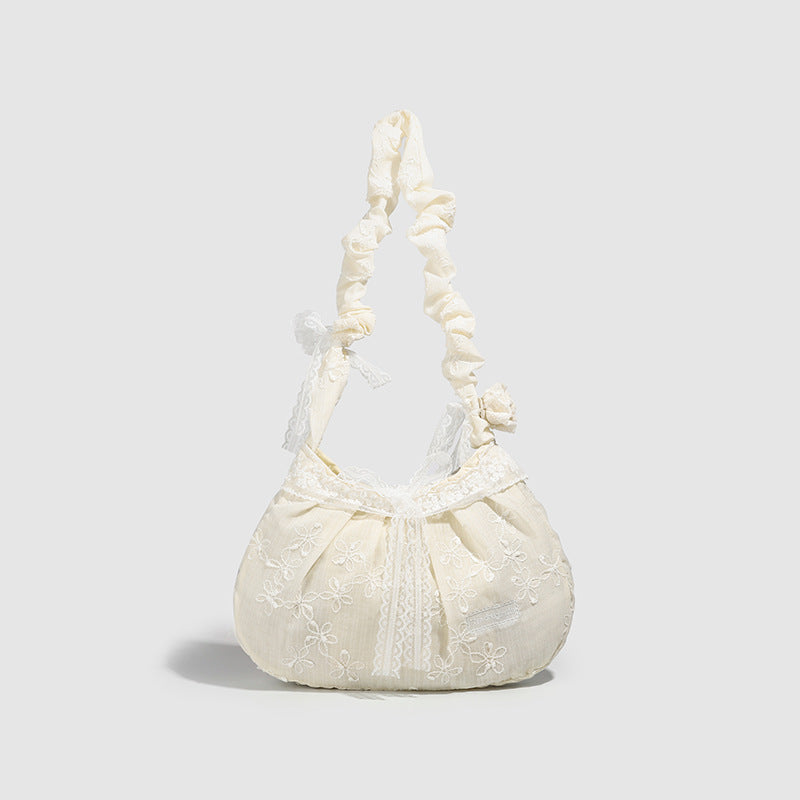 Elfenbeinfarbene, halbmondförmige Schultertasche mit Blumenstickerei, Spitzenbesatz und gerafftem Rüschenstoffriemen mit Schleifendetail, Detailansicht