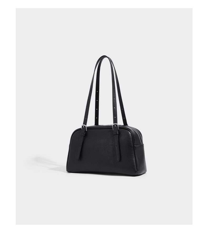 Structured dome-shaped shoulder bag with leather-look finish, top zipper closure, dual adjustable slim straps, and, detail