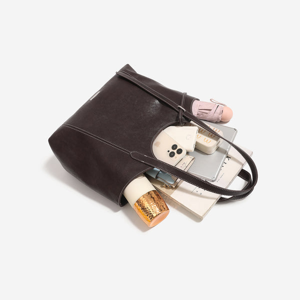 Strukturierte Tote-Tasche in Lederoptik mit zwei langen Schulterriemen, Bindebanddetail auf der Vorderseite und kontrastierenden weißen Steppnähten, Detailansicht
