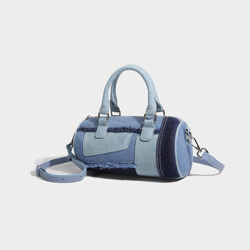 Mini barrel handbag in light and dark denim patchwork with frayed seam trim, dual top handles, top zip closure, and, front