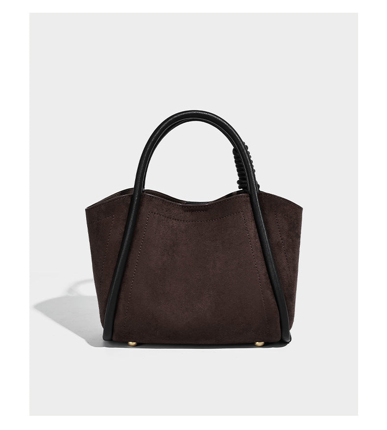 Kleine, strukturierte Tote-Bag mit offenem Design in Dunkelbraun und matter Wildlederoptik, mit schwarzen geknoteten Tragegriffen und befestigtem Front