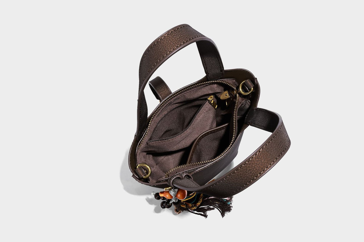 Kleine matte Beuteltasche mit genarbter Oberfläche, antikgoldfarbenen Ringbeschlägen, Perlen- und Quastenanhänger, kurzen Tragegriffen oben und