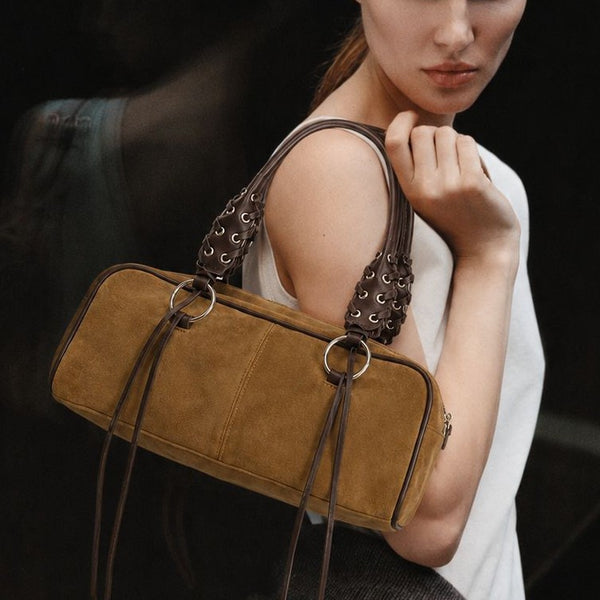Rectangular suede-look barrel bag with laced eyelet handles, silver O-ring hardware, and hanging leather-look fringe tie