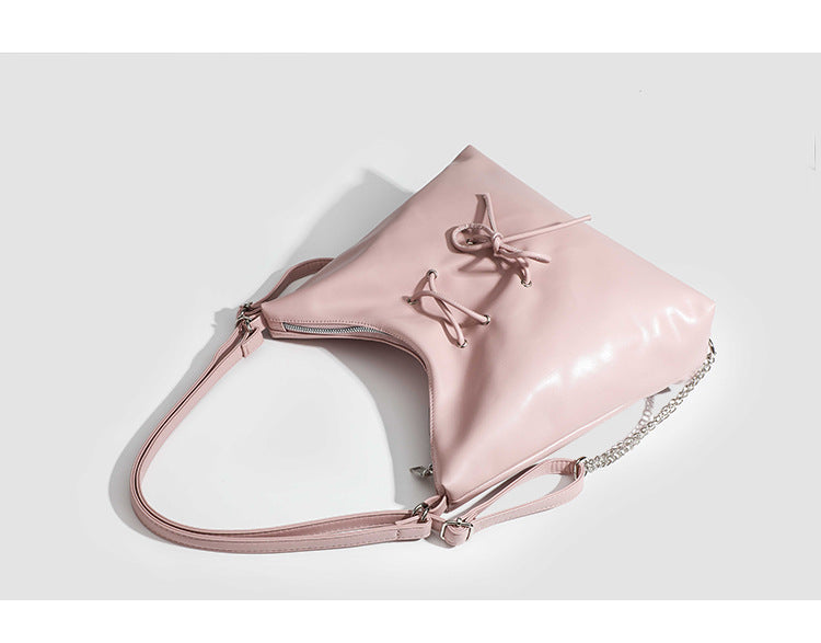 Glossy leather-look hobo shoulder bag with front bow lacing detail and silver-tone chain strap, detail view 9