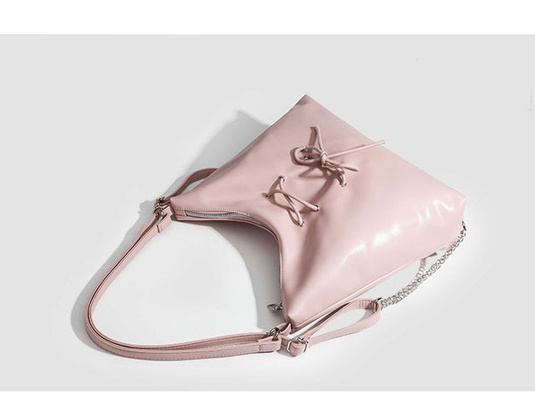 Glossy leather-look hobo shoulder bag with front bow lacing detail and silver-tone chain strap, detail view 9
