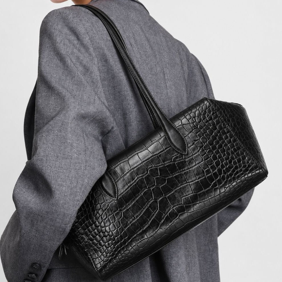 Black glossy croc-embossed trapezoid shoulder bag with double rounded straps and zip closure, detail view 2